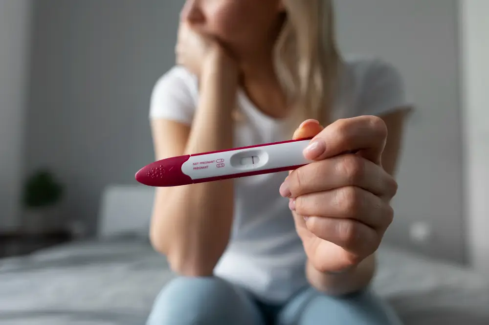 Woman holding a pregnancy test while trying to conceive, infertility treatment