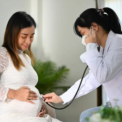 Antenatal care in Delhi: doctor checking a pregnant woman with a stethoscope